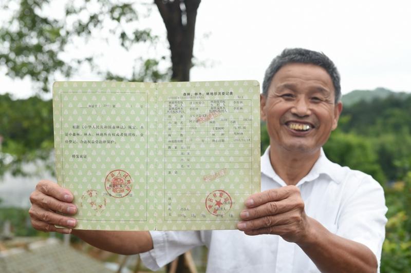 2017年6月13日，福建武平县万安镇捷文村村民李桂林展示林权改革后领到的全国第一本新式林权证。